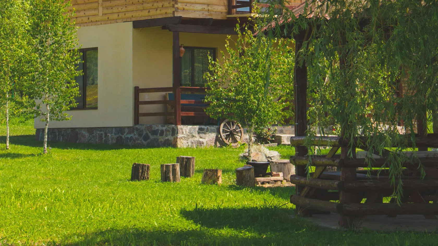 Maison en bois avec jardin verdoyant, entouré d'arbres et de rondins, solution anti-taupe, piège à taupe, détaupeur, detaupeur, quicktaupe, se debarrasser des taupes, tuer les taupes, éliminer les taupes, faire partir les taupes, faire fuir les taupes, anti-taupe.